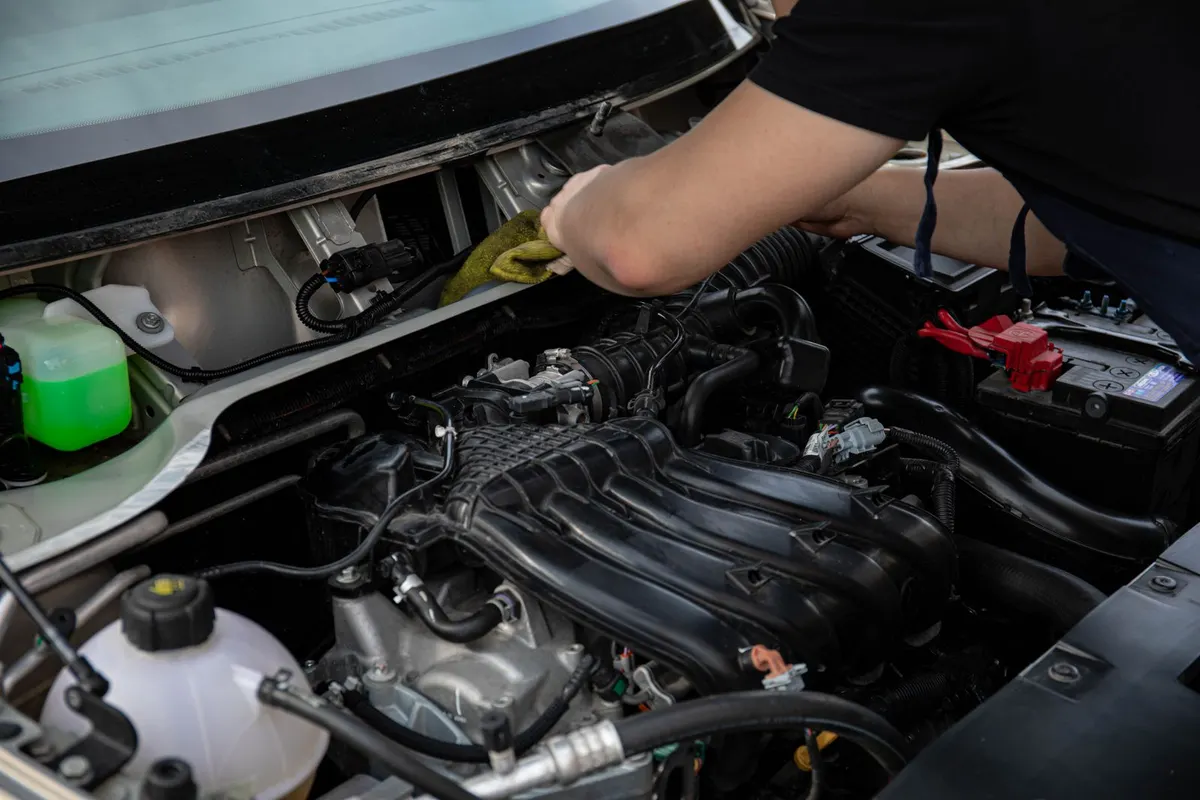 Mechaniker prüft Motorkomponenten auf Verschleiß in einer deutschen Kfz-Werkstatt