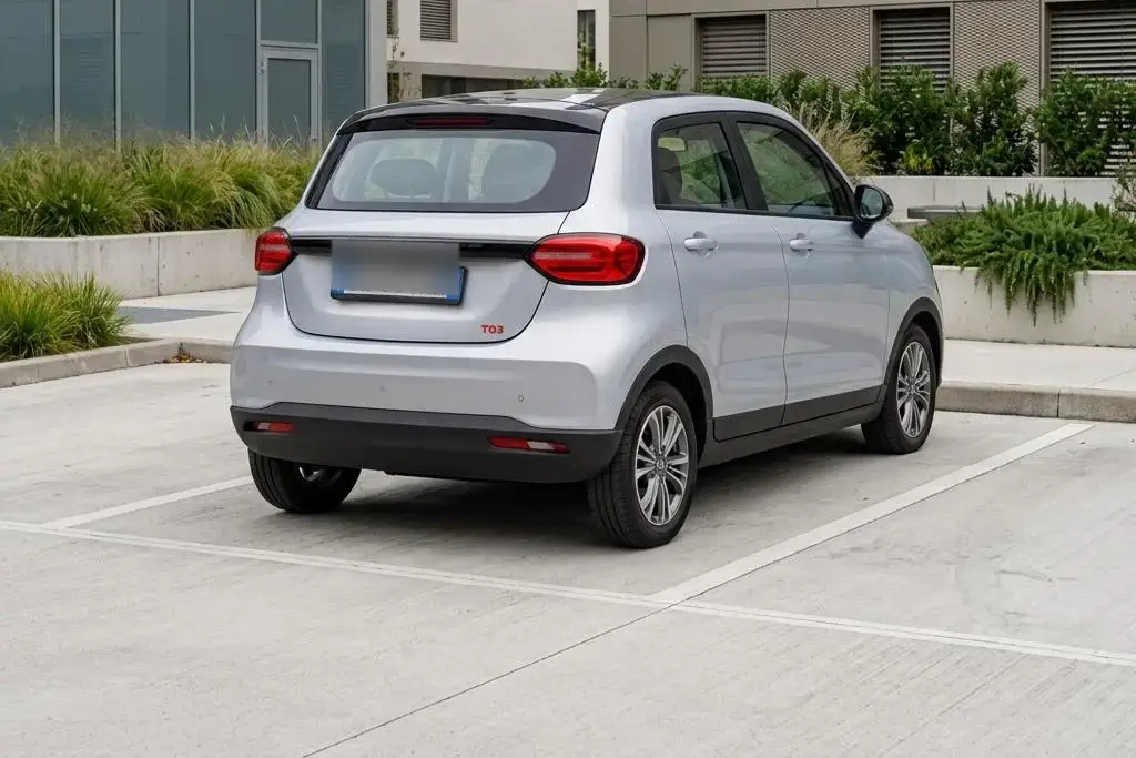 Leapmotor T03 Test: weißer Elektro-Kleinwagen mit unkenntlichem Kennzeichen auf einem Stadtparkplatz